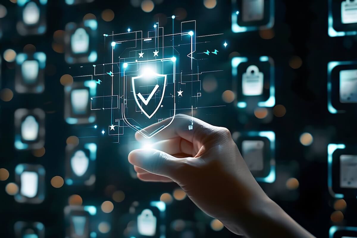 A hand appears to be gently holding a point of light between thumb and forefinger. It’s lighting up a shield that is hovering the air and has a large, white checkmark on it.